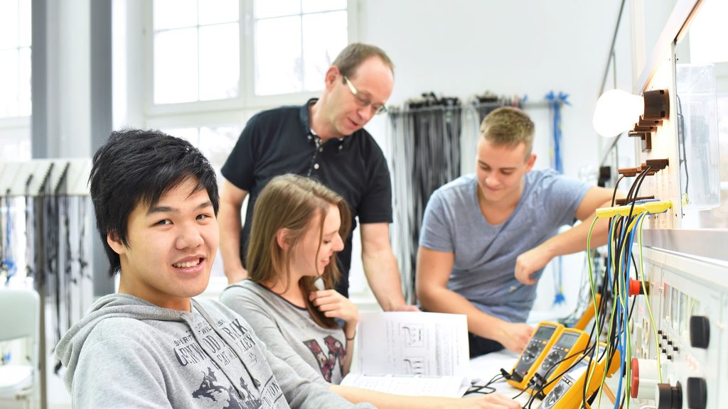 Group of young people in technical vocational class with teacher